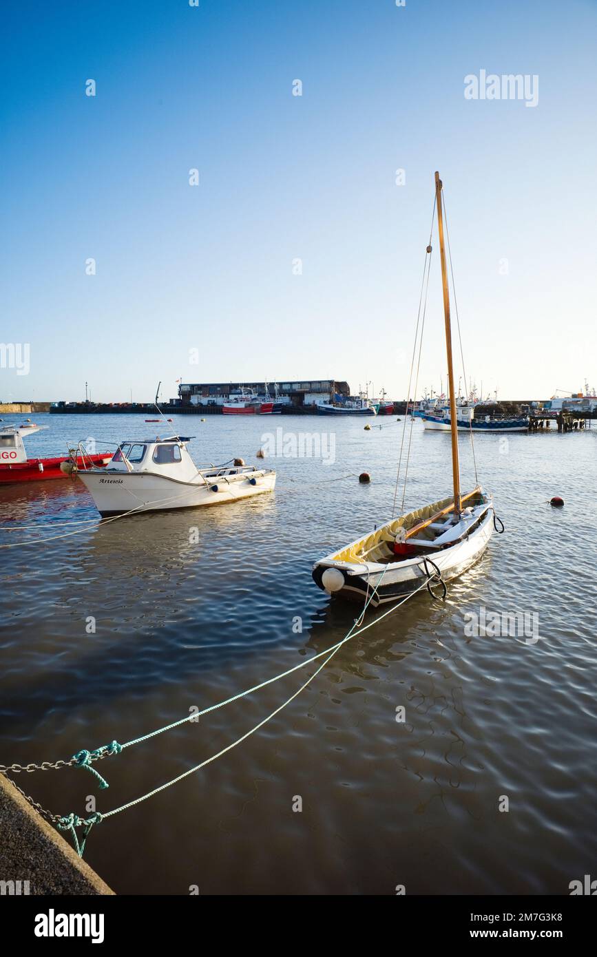 Porto di Bridlington con barca a vela in ciottoli in primo piano Foto Stock