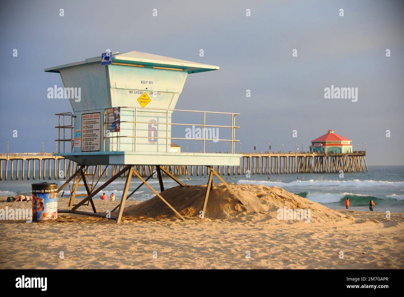 Una torre del bagnino su una spiaggia californiana al tramonto. Molto indietro è Huntington Beach Pi Foto Stock