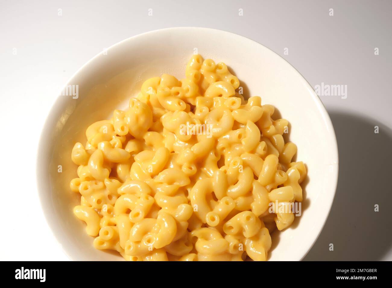 maccheroni con formaggio su fondo bianco, macrofone Foto Stock