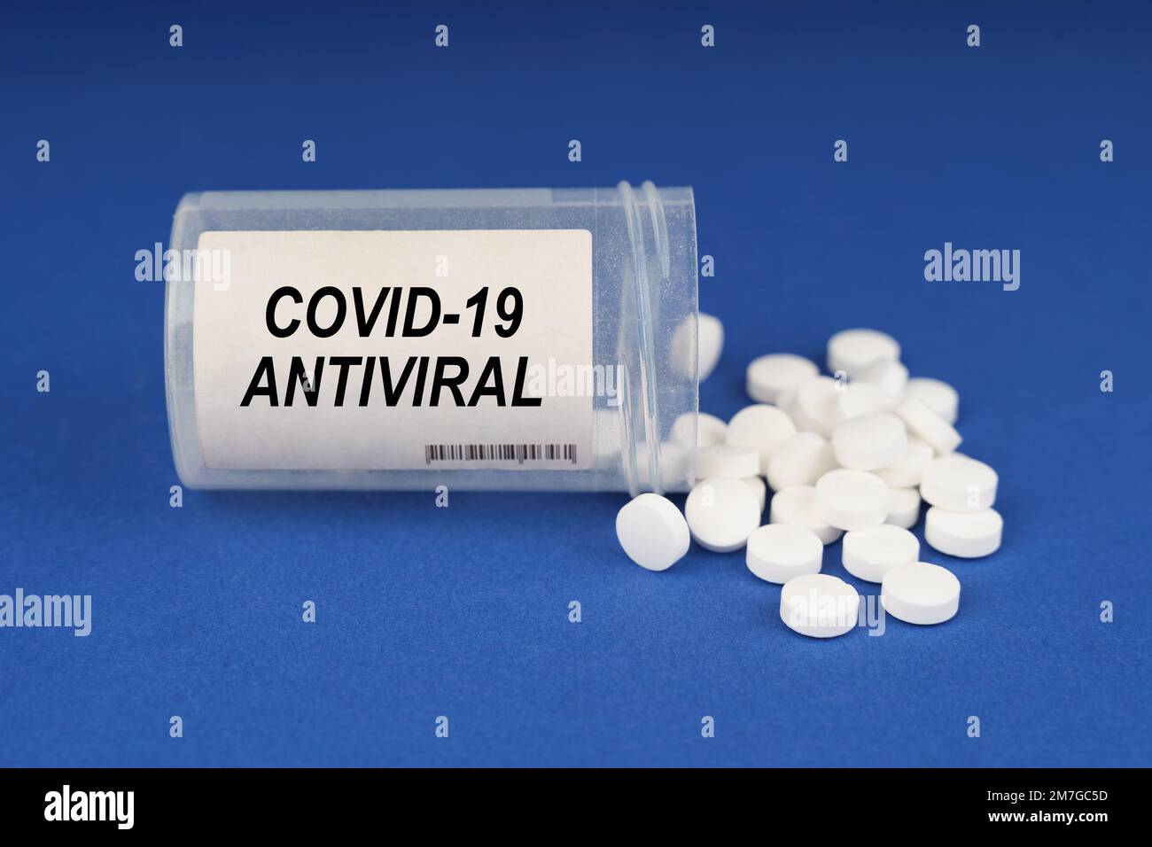 Il concetto di farmacologia e salute. Su una superficie blu sono le pillole e un vaso polveroso con l'iscrizione - antivirale Covid-19 Foto Stock