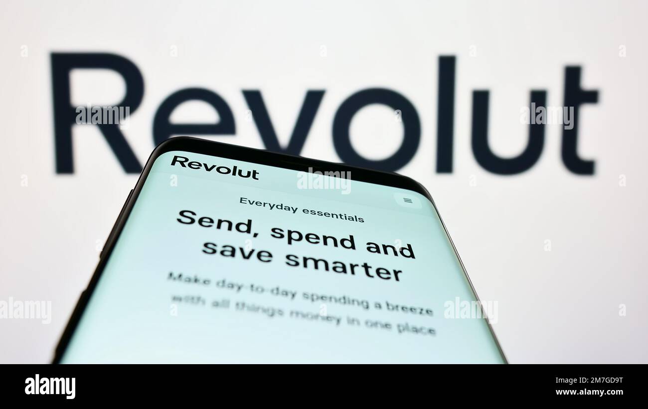 Telefono cellulare con pagina web della società britannica Revolut Ltd. Fintech sullo schermo di fronte al logo aziendale. Messa a fuoco in alto a sinistra del display del telefono. Foto Stock