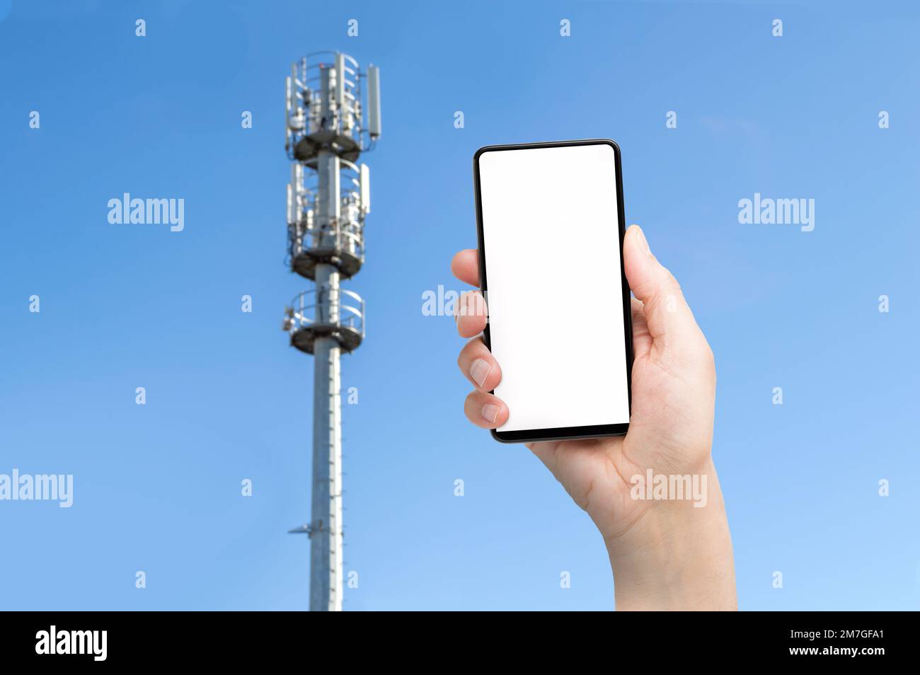 5G torre di comunicazione con l'uomo che utilizza uno smartphone mobile Foto Stock