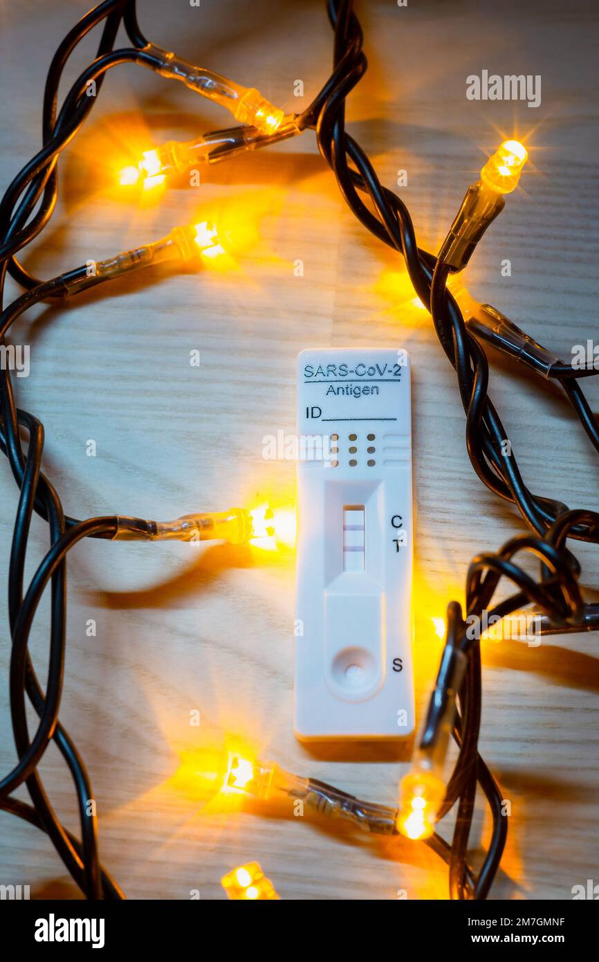 Test corona positivo con luci natalizie sullo sfondo Foto Stock