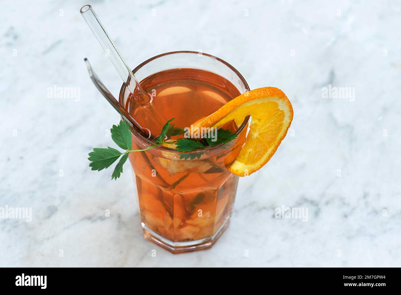 Bicchiere con succo di mela cotogna, fetta d'arancia e un bicchiere di paglia, Baviera, Germania Foto Stock