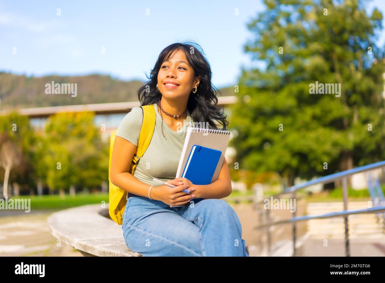Ragazza asiatica nel campus, studente con blocchi in mano e zaino, sorridente all'università Foto Stock