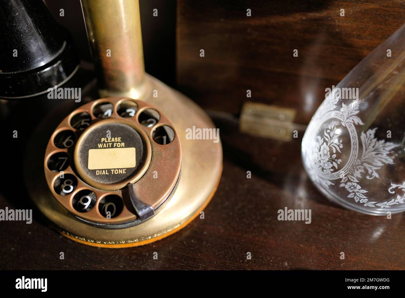 Base di un primo 1900s Western elettrico Ottone Bullnose Candlestick Rotary Dial Telefono con si prega di attendere la scritta del tono di composizione sulla composizione del numero. Foto Stock
