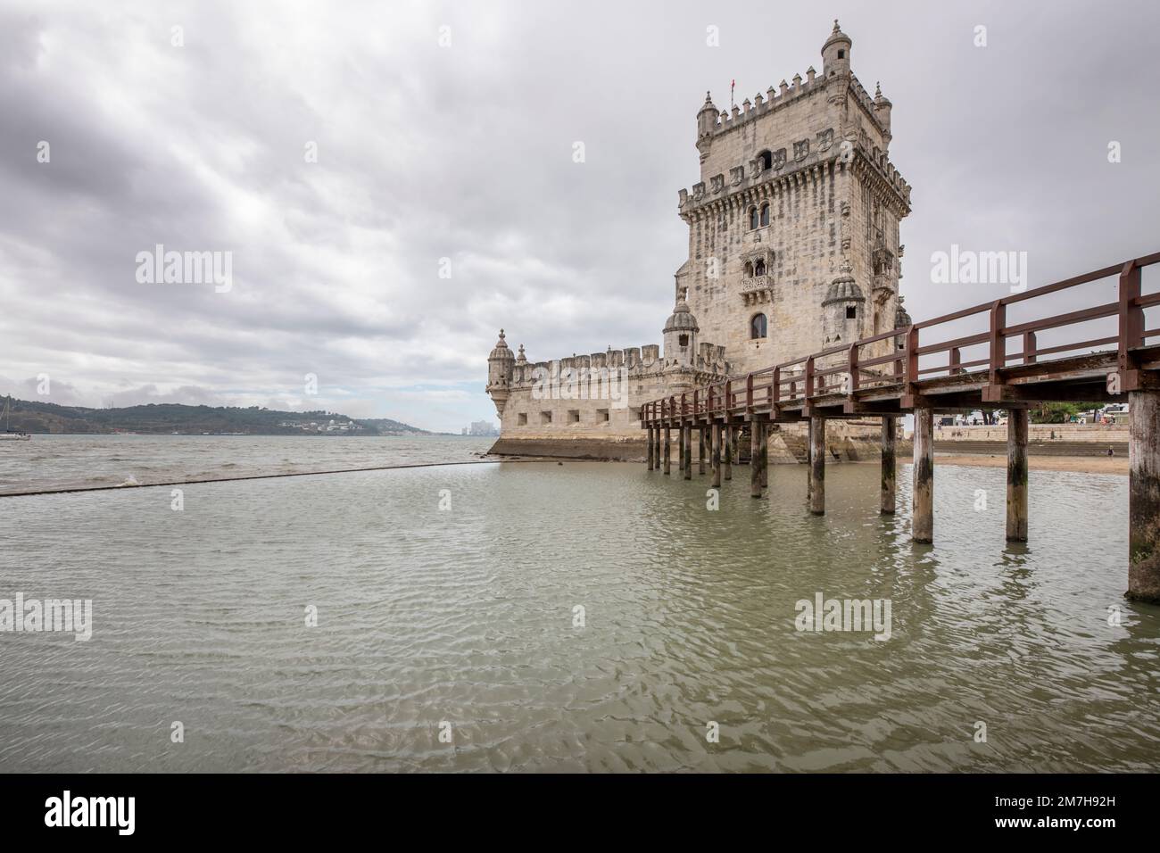 Edificio Torre de belem a Lisbona con una passerella in legno in una giornata nuvolosa Foto Stock