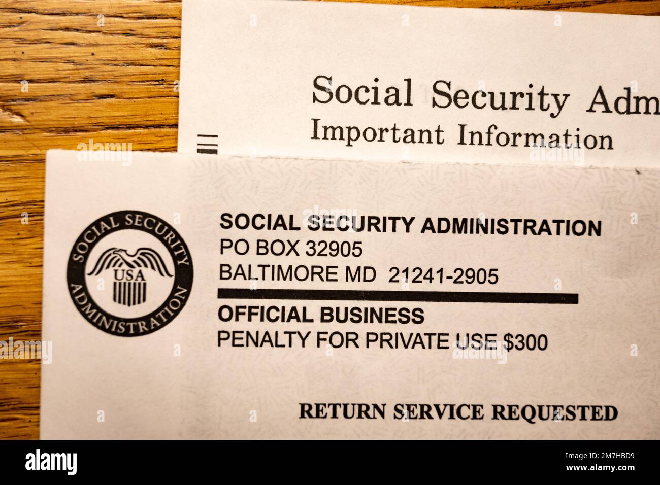 Lettera e busta di informazioni importanti dell'amministrazione della previdenza sociale degli Stati Uniti su un banco di quercia. Foto Stock
