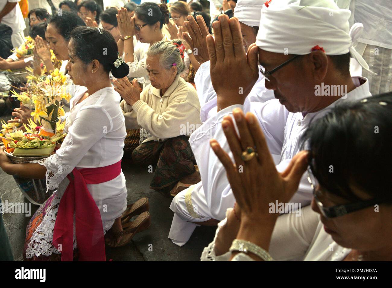 Un clan balinese sta pregando insieme durante un rituale per onorare e purificare gli spiriti dei loro ultimi membri della famiglia, in un tempio situato nel complesso del tempio di Besakih, sul pendio del Monte Agung a Karangasem, Bali, Indonesia. Foto Stock