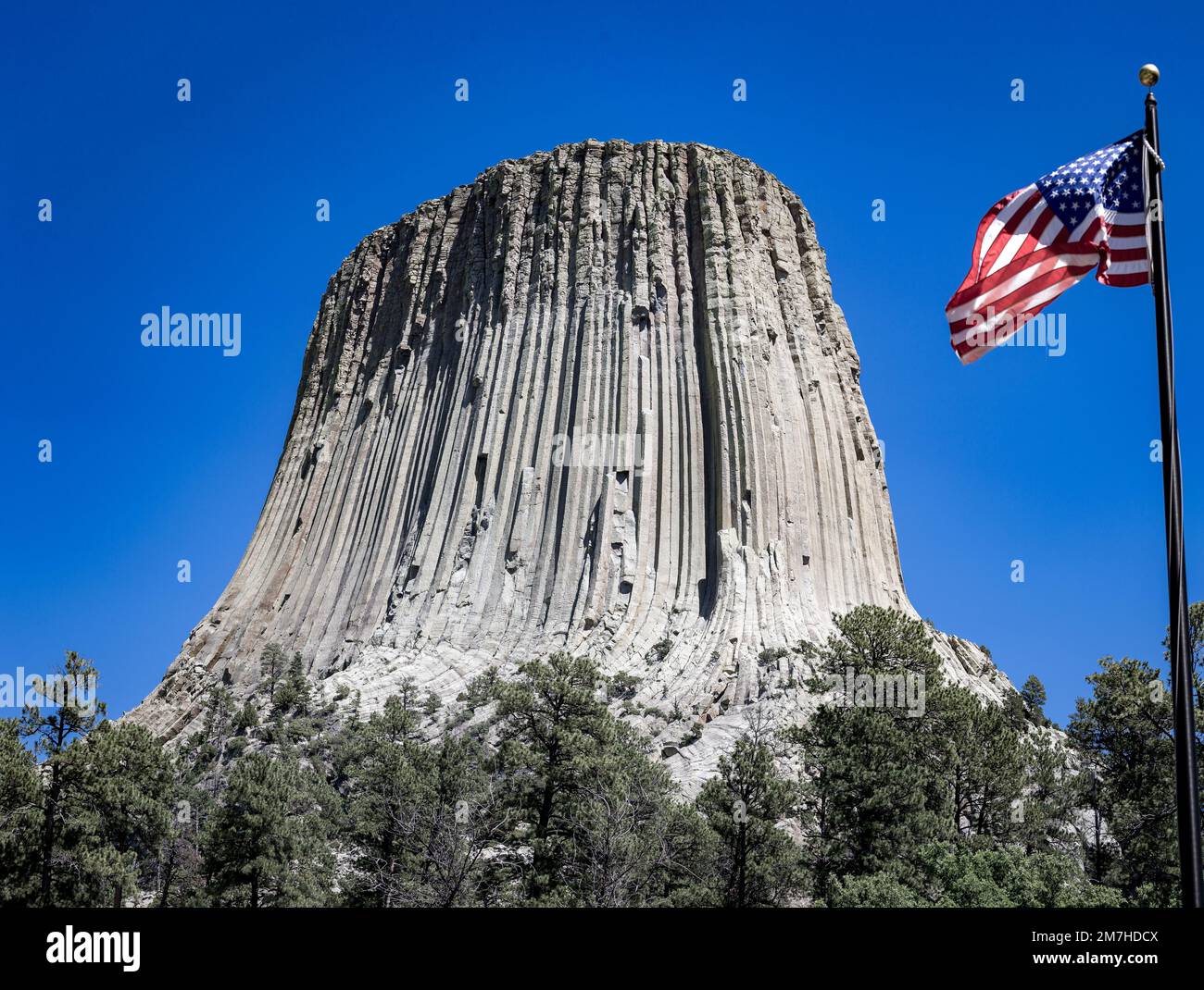 Il famoso Devils Tower National Monument e una bandiera americana nel Wyoming, USA Foto Stock