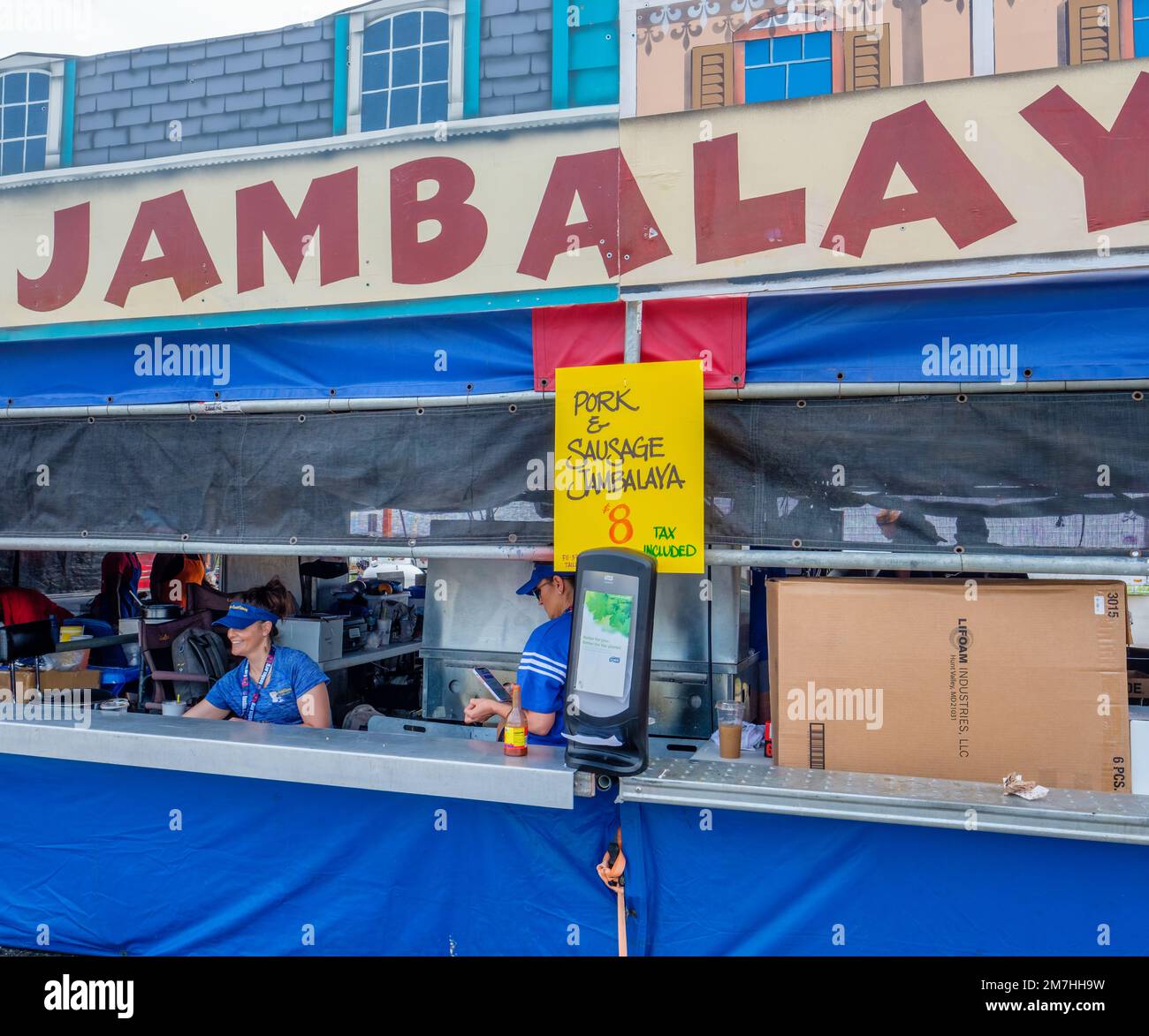 NEW ORLEANS, LA, USA - 1 MAGGIO 2022: Servers al banco del Jambalaya food stand al New Orleans Jazz and Heritage Festival Foto Stock