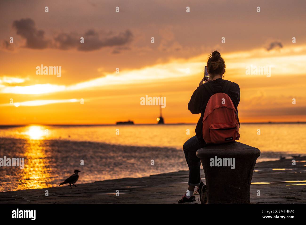 Giovane ragazza al Molo Audace (molo) durante il tramonto. Trieste, Italia. Foto Stock