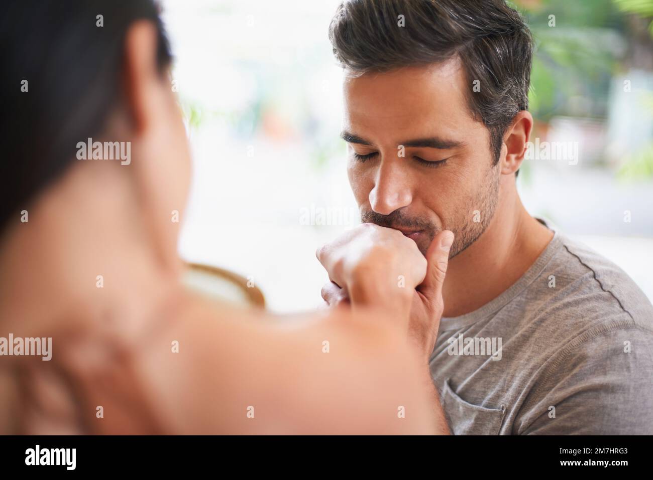 Il mio carissimo...un uomo affascinante che bacia la sua mano in un ristorante. Foto Stock