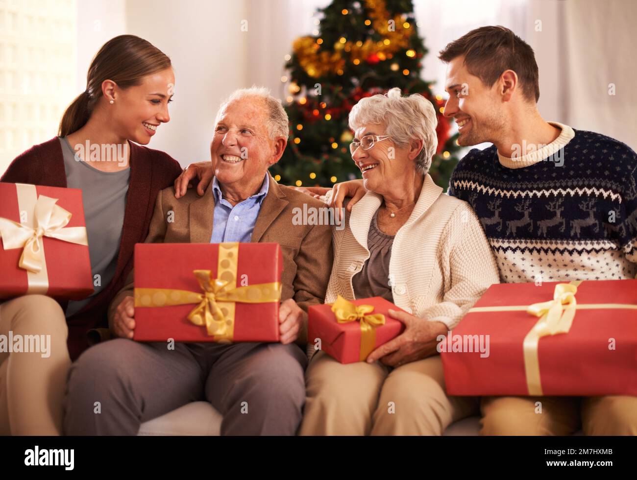 Dare i regali è che cosa Natale è interamente circa. Una famiglia felice che tiene i loro regali di Natale. Foto Stock