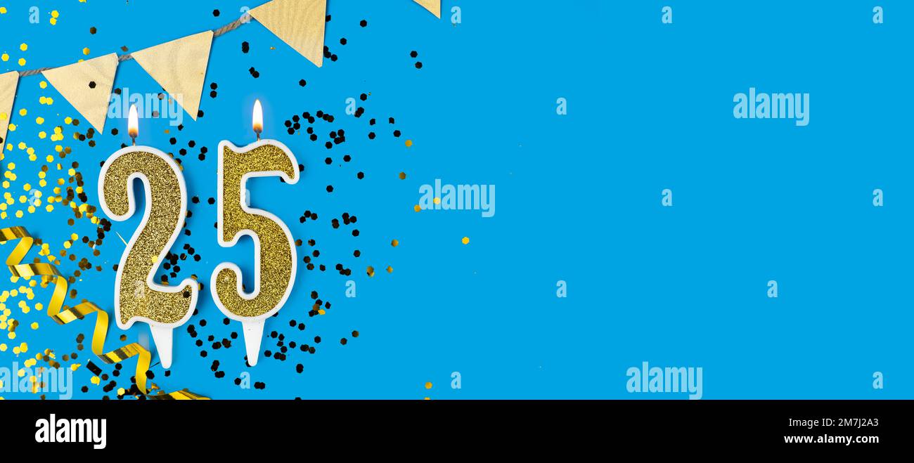 Candela d'oro numero 25 su sfondo stella e blu glitter. Spazio di copia. Foto Stock