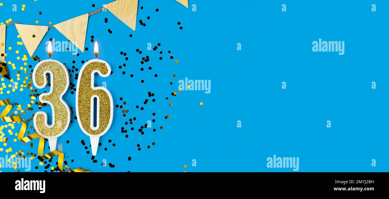 Candela d'oro numero 36 su sfondo blu. Foto Stock