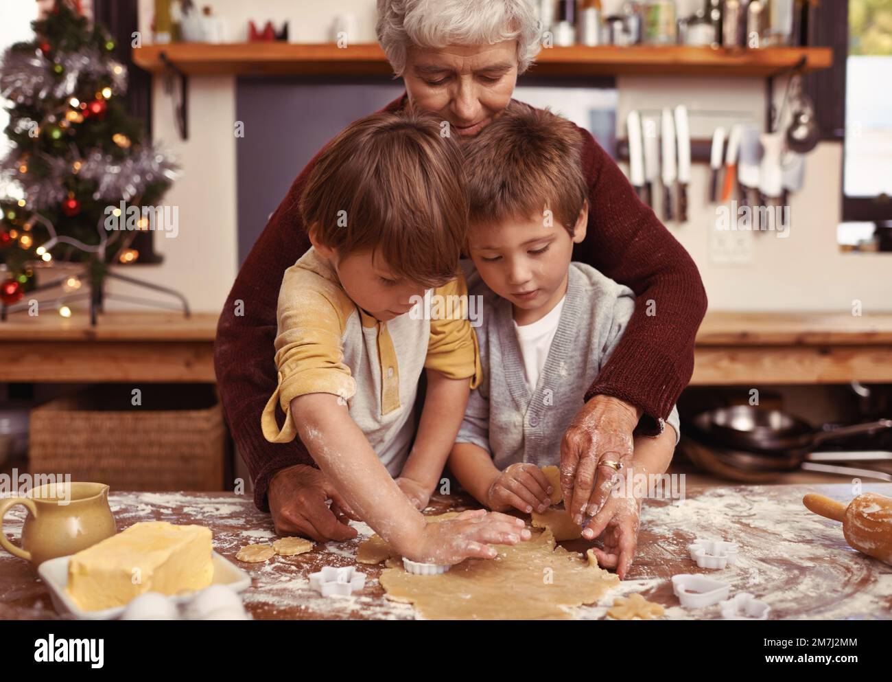 Grannys piccolo aiuto cucina. Due simpatici ragazzini che cucinano con la nonna in cucina. Foto Stock