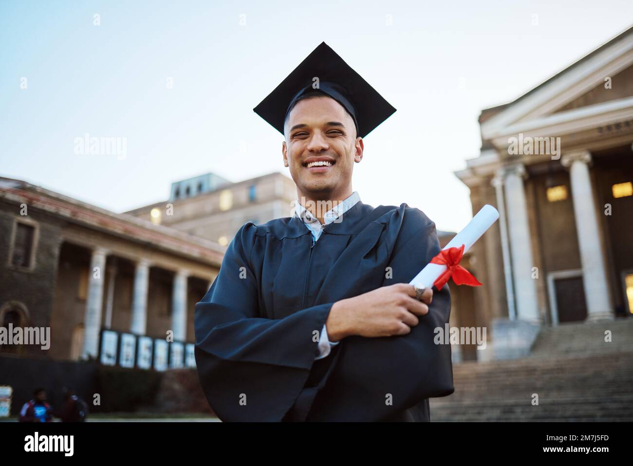 Università, laurea e uomo felice con un diploma di scuola in piedi fuori dal suo campus. Istruzione, borse di studio e laureato dal Messico con Foto Stock