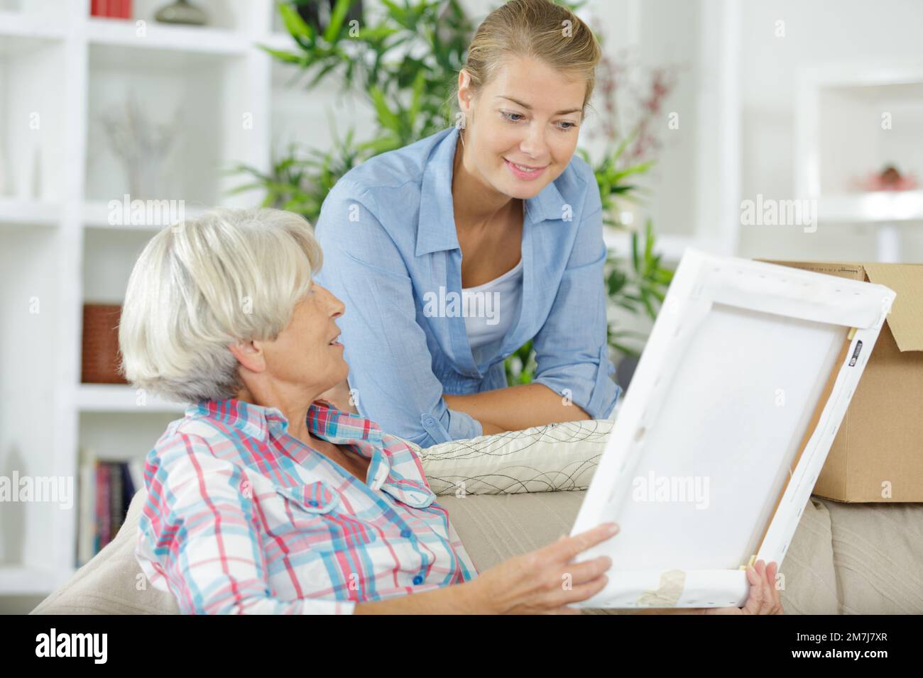 madre con figlia che guarda la cornice fotografica Foto Stock