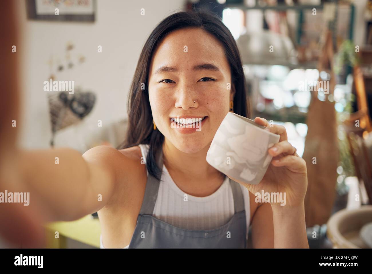 Selfie, arte ceramica e creativa donna asiatica sorridere in ceramica studio o culto per il design di prodotti di tazza, la creatività culturale e lo sviluppo artistico Foto Stock