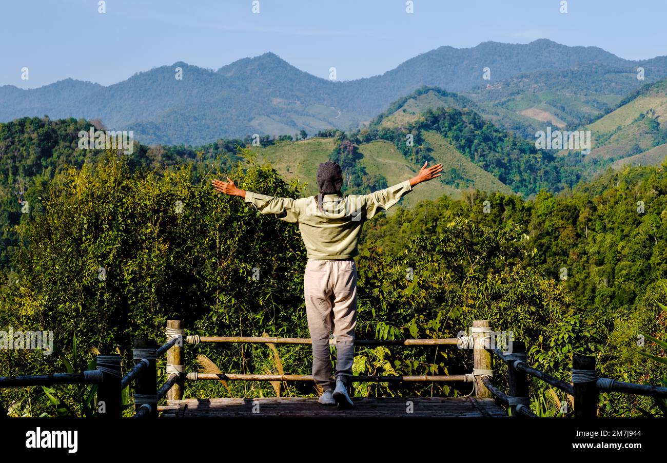 Donne asiatiche con le mani in su che guardano fuori sulle montagne della Thailandia del nord Nan Sapan valle. Foto Stock