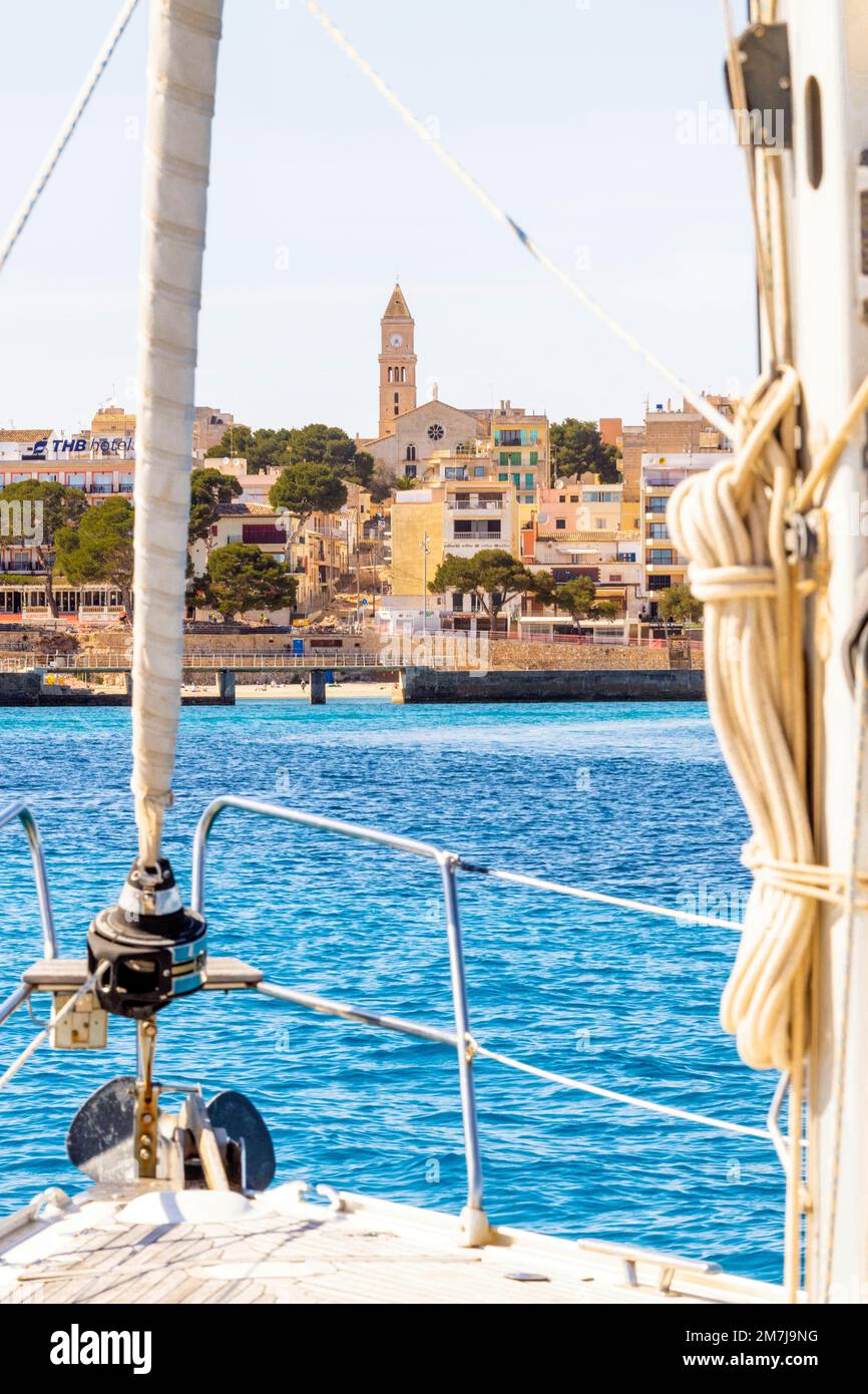 Uno yacht a vela entra nella baia di Porto Cristo. Da lontano, la guglia della chiesa della cittadina sulla costa orientale di Maiorca ci accoglie.Dorf Foto Stock