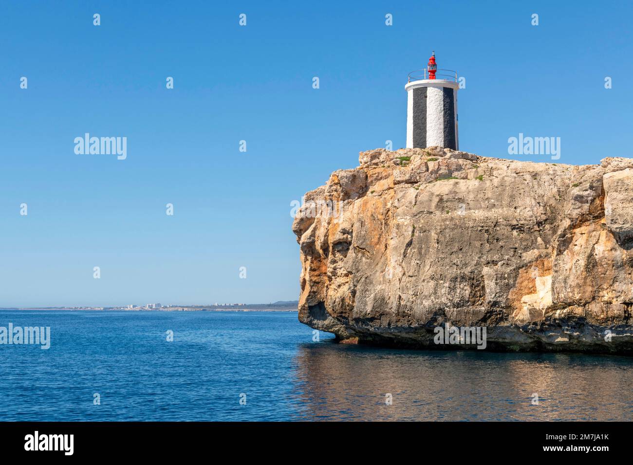 Il faro sulla roccia Morro de SA Carabassa all'ingresso della baia di Porto Cristo, sulla costa orientale di Maiorca. Foto Stock