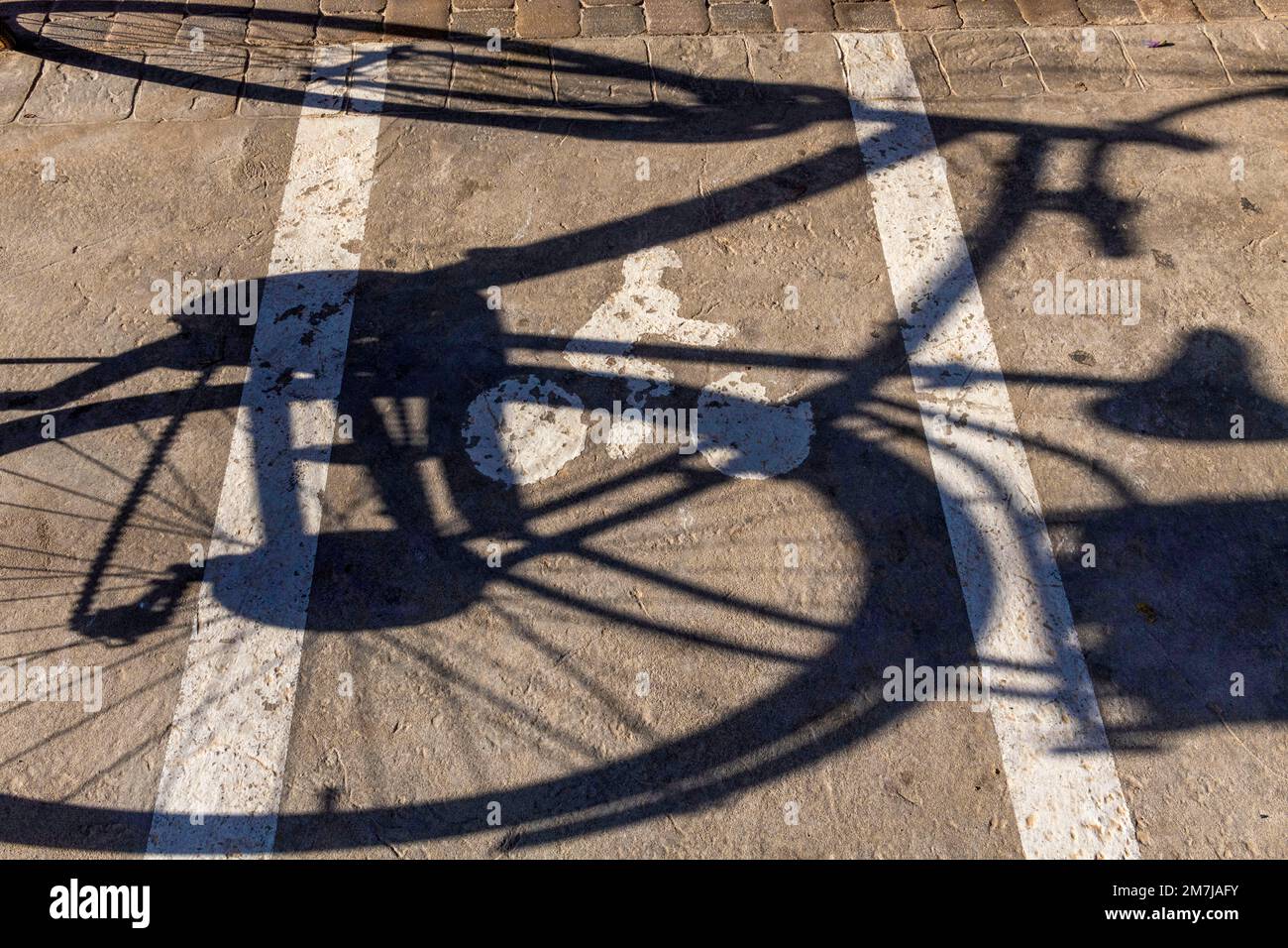 Ombra di una bicicletta su un parcheggio per biciclette Foto Stock