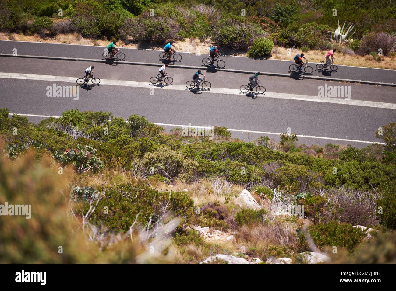 In bicicletta attraverso la campagna. Un gruppo di ciclisti sulla superstrada. Foto Stock