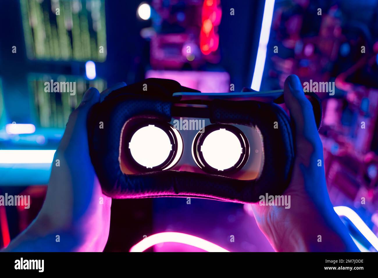 La prospettiva degli occhi delle mani delle persone che indossano cuffie per realtà virtuale 3D 360, occhiali per realtà aumentata in un ambiente futuristico con luce al neon. Esperienza tecnologica di innovazione VR AR Foto Stock