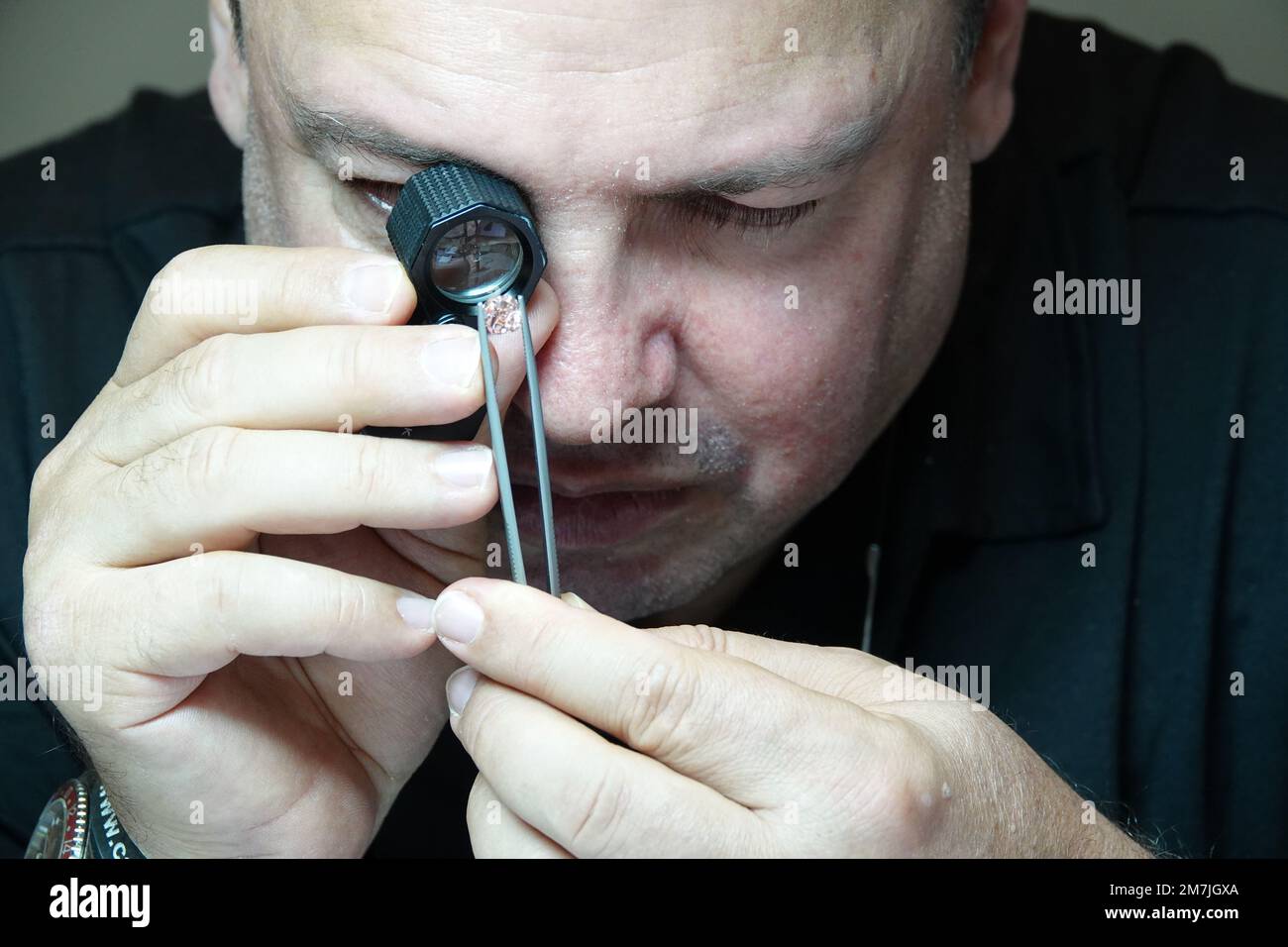 Kapstadt, Sudafrica. 26th Ott 2022. Yair Shimansky, fondatore dell'omonimo marchio sudafricano di gioielli, analizza un raro diamante rosa con una lente d'ingrandimento nel suo negozio di gioielli a Città del Capo. La guerra di aggressione russa contro l'Ucraina sta attualmente rafforzando la tendenza contro i diamanti da conflitto. Credit: Kristin Palitza/dpa/Alamy Live News Foto Stock