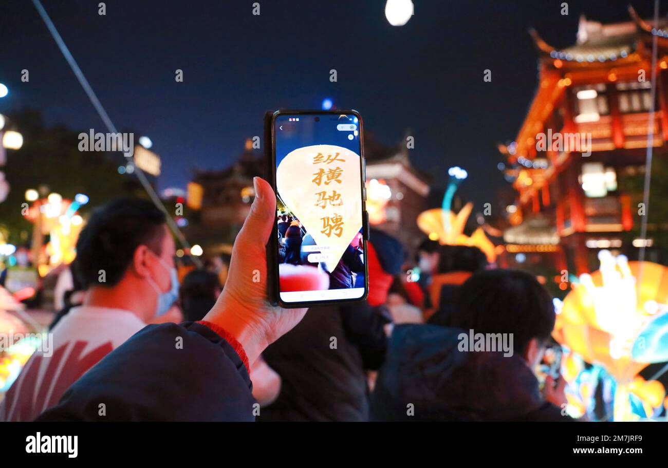 SHANGHAI, CINA - 7 GENNAIO 2023 - i visitatori possono sperimentare la tradizionale fiera delle lanterne di arte popolare al Tempio del Dio della Città Vecchia tramite AR sui loro telefoni cellulari Foto Stock