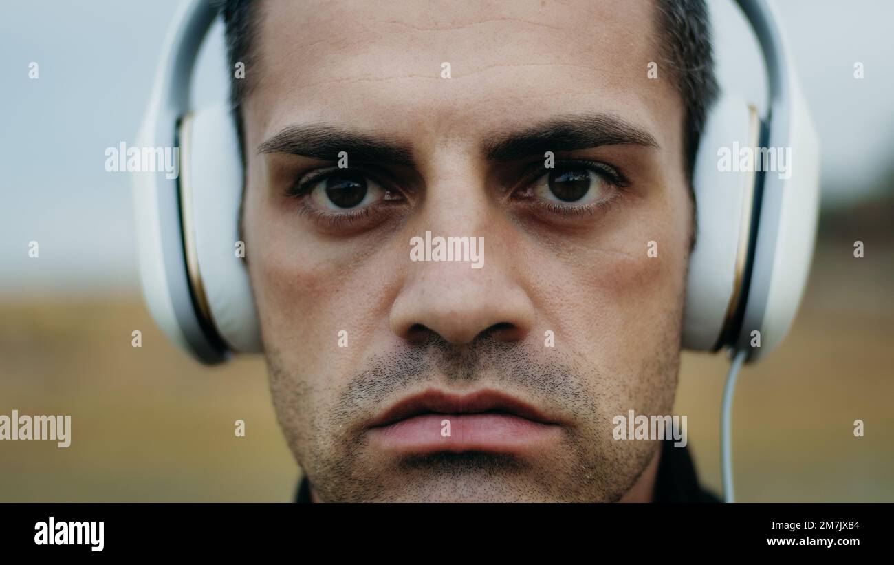 Il ragazzo concentrato ascolta la musica dalle cuffie prima di fare sport Foto Stock