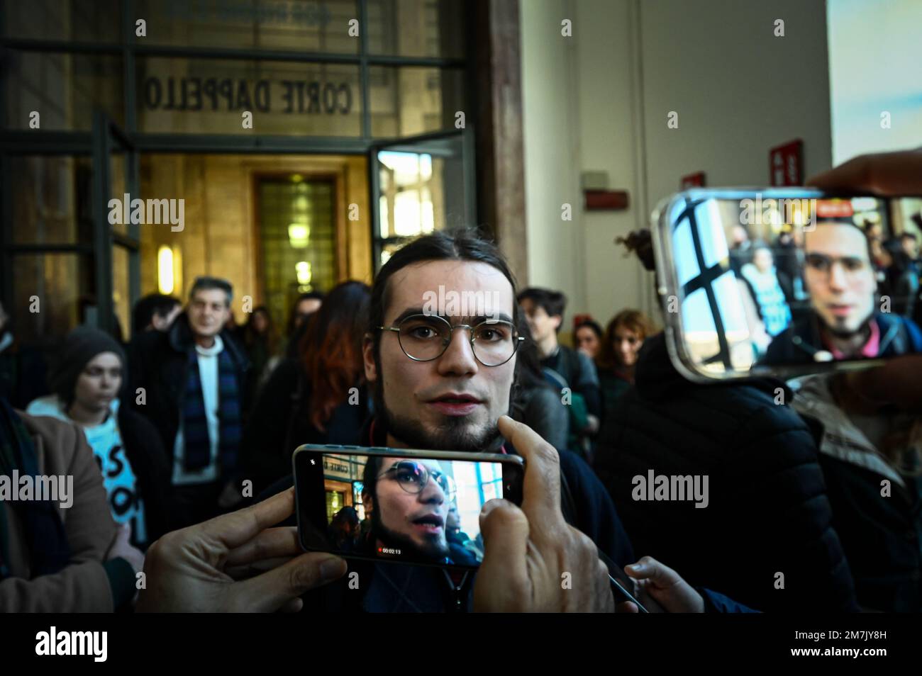 Milano, Italia. 10th gennaio 2023. Simone Ficchia, attivista ambientale di ultima generazione, parla alla stampa dopo l'audizione alla Corte di giustizia di Milano il 10 gennaio 2023. L'attivista di ultima generazione, 20 anni, si trova di fronte all'applicazione di speciali misure di sorveglianza dopo aver spruzzato recentemente vernice lavabile all'ingresso del teatro la Scala e dopo aver attecchito alla Primavera di Botticelli agli Uffizi di Firenze per sensibilizzare il pubblico sui cambiamenti climatici. Credit: Piero Crociatti/Alamy Live News Foto Stock