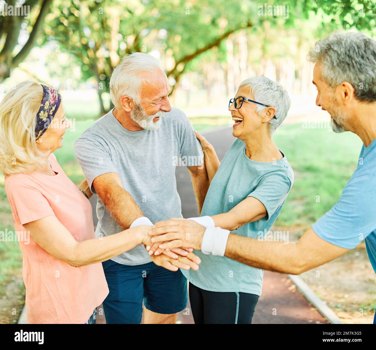 outdoor senior fitness donna uomo stile di vita sport attivo esercizio sano fitness pensione squadra insieme tenendo le mani Foto Stock