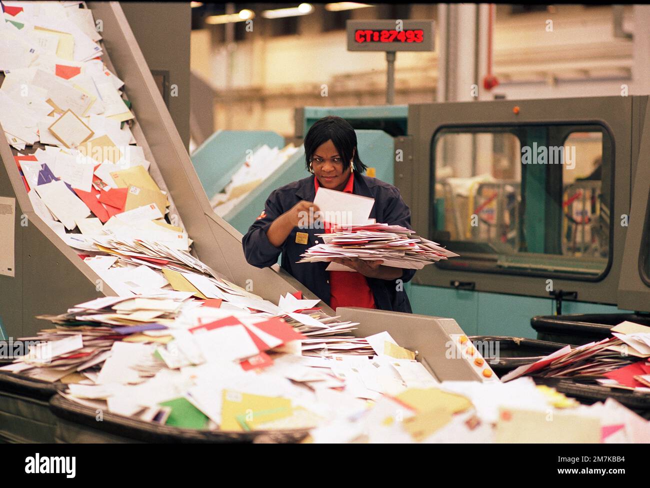 Lavoratore postale alla fine degli anni '90 smistamento attraverso la posta di Natale in arrivo a Mount Pleasant smistamento ufficio, nel centro di Londra, Inghilterra, Regno Unito Foto Stock