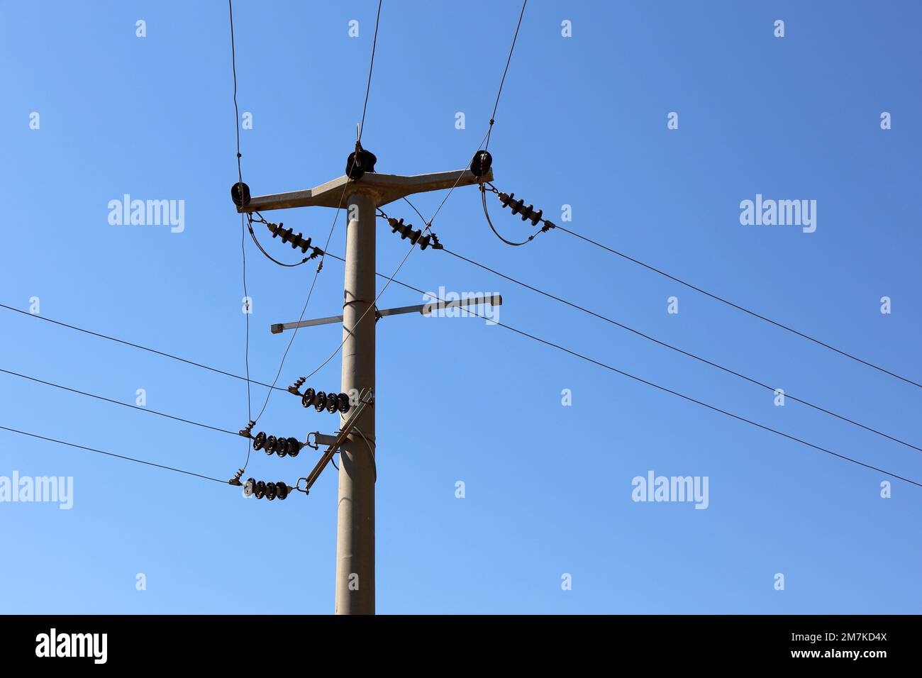 Morsetto della linea di alimentazione con cavi elettrici e condensatori su sfondo blu cielo. Linea di trasmissione elettrica, alimentazione elettrica Foto Stock