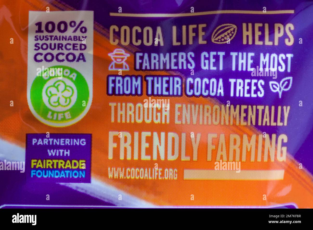 Il 100% reperisce in modo sostenibile informazioni sul Cocoalife di cacao sul pacchetto di Cadbury Dairy Milk Orange Foto Stock