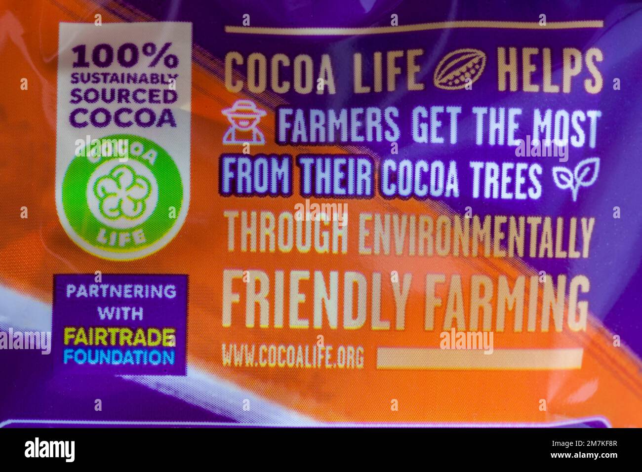 Il 100% reperisce in modo sostenibile informazioni sul Cocoalife di cacao sul pacchetto di Cadbury Dairy Milk Orange Foto Stock