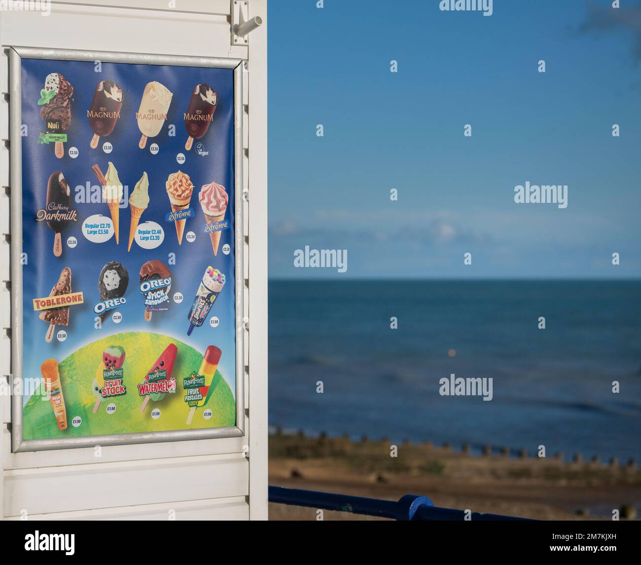 Listino prezzi del chiosco dei gelati con spiaggia invernale dietro. Eastbourne, East Sussex, Regno Unito Foto Stock