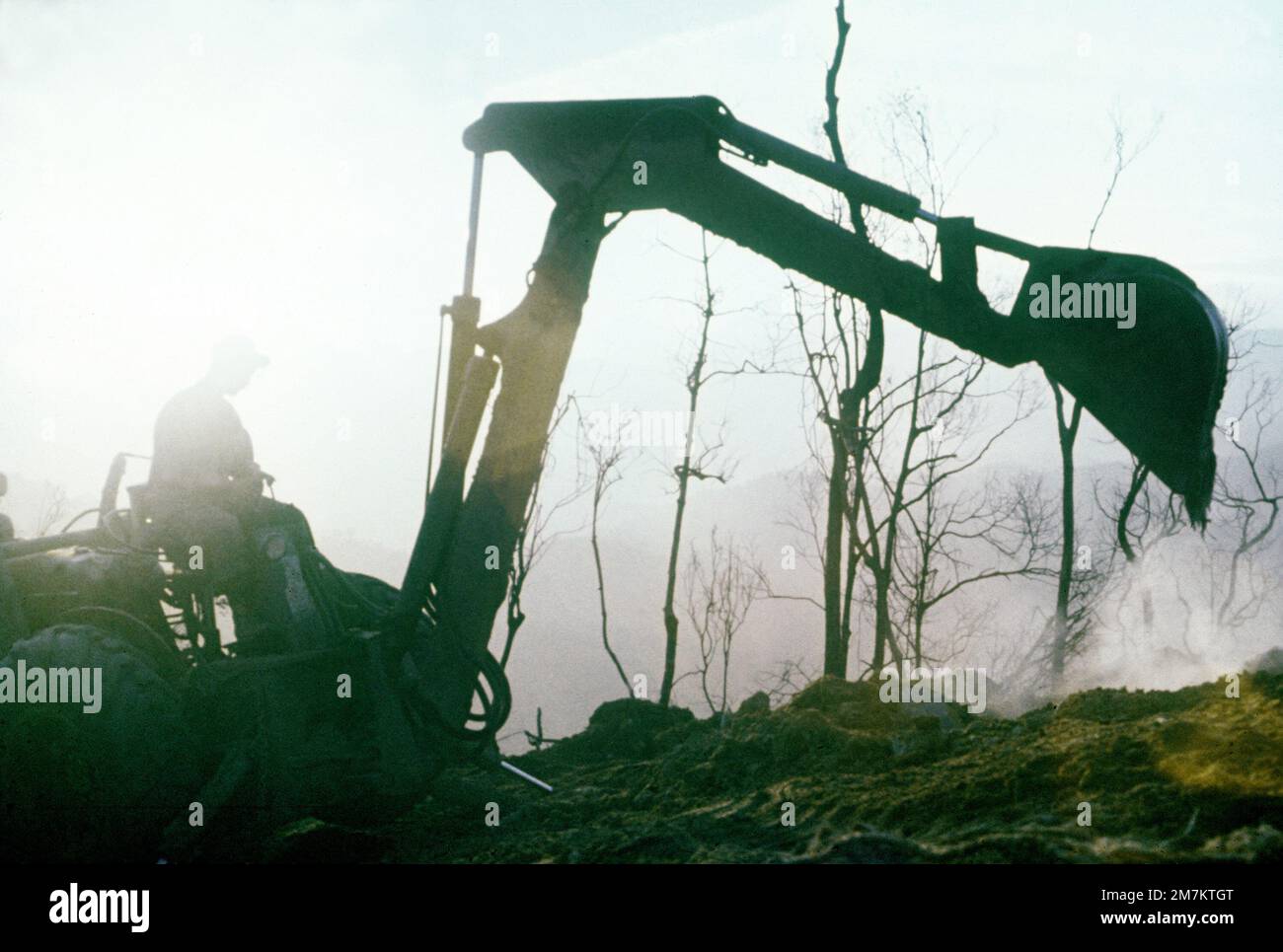 Un membro della divisione Marine 3rd utilizza una combinazione di retroescavatore/caricatore frontale per il livellamento del cantiere di una base antincendio in cima a una montagna. Paese: Viet Nam (VNM) Foto Stock