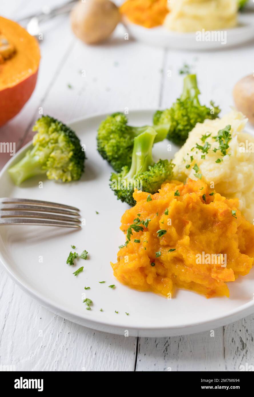 Piatto con contorni sani, caldi e senza glutine. Come broccoli, purè di patate e purea di zucca rossa kuri Foto Stock