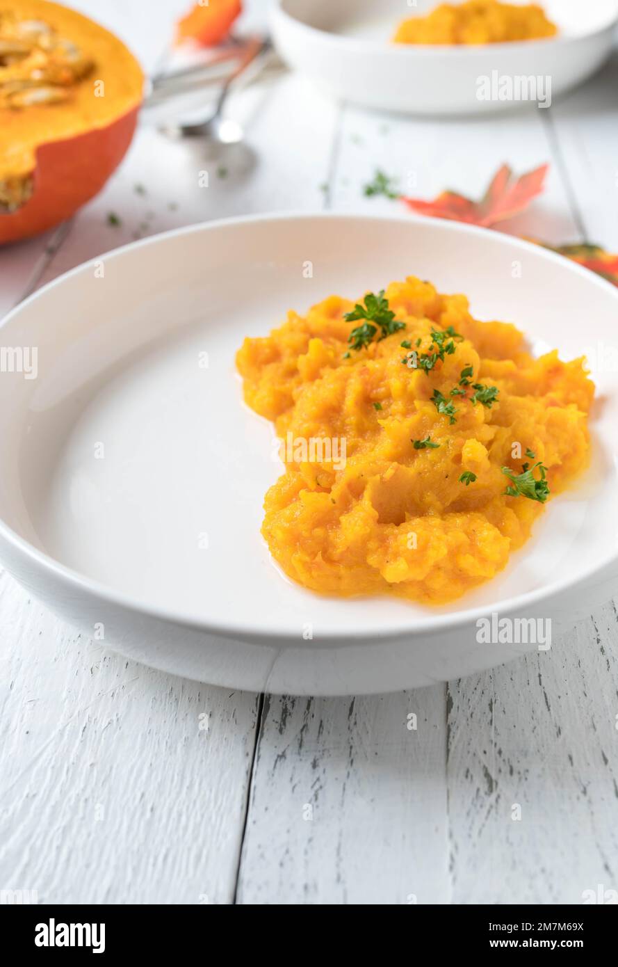 Purea di zucca servita per contorno su un piatto su sfondo bianco. Foto Stock