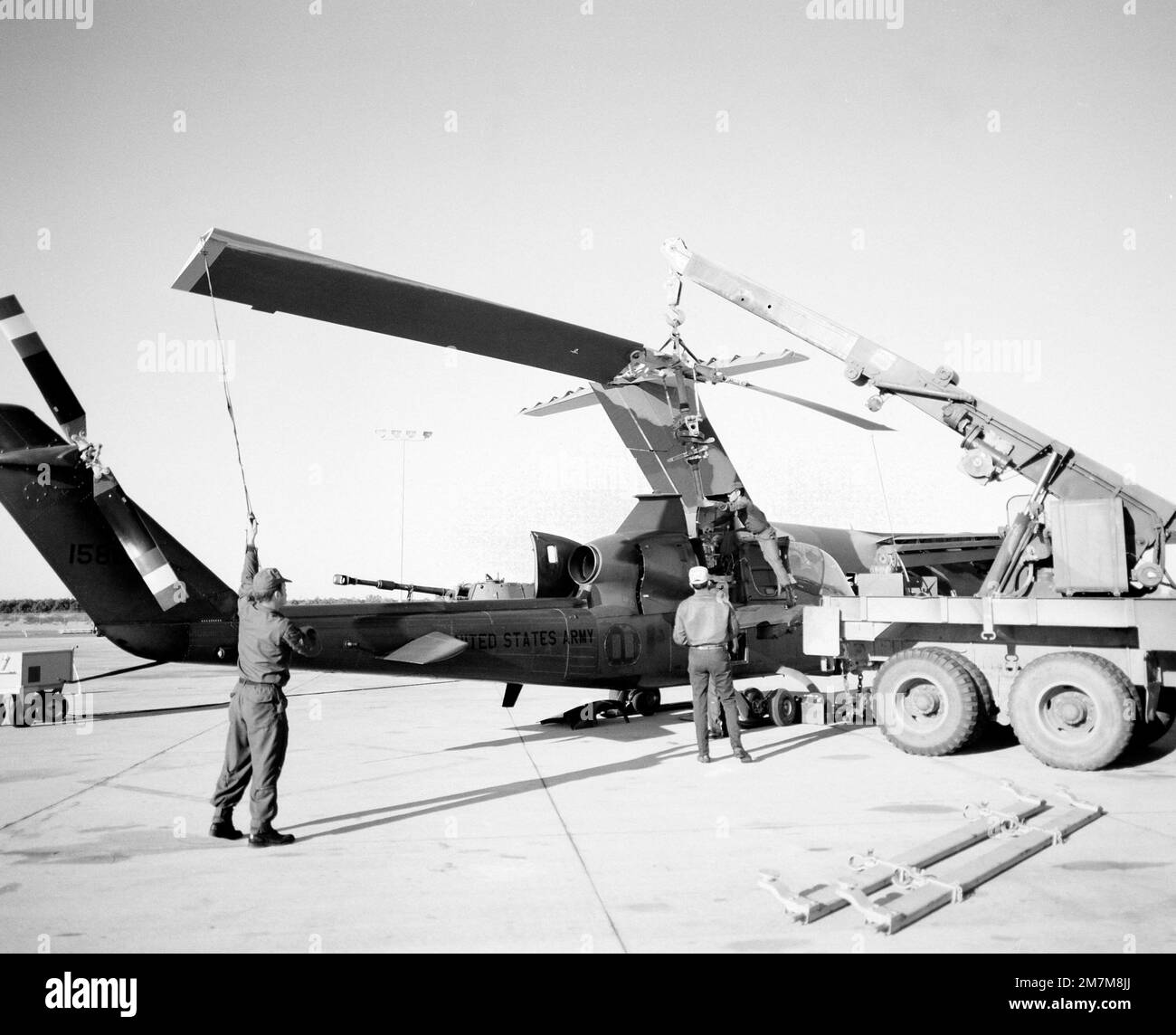 Le pale del rotore vengono rimosse prima di caricare un elicottero AH-1G Cobra a bordo di un aeromobile YC-15 durante un test di carico pesante. Base: Yuma Stato: Arizona (AZ) Nazione: Stati Uniti d'America (USA) Foto Stock