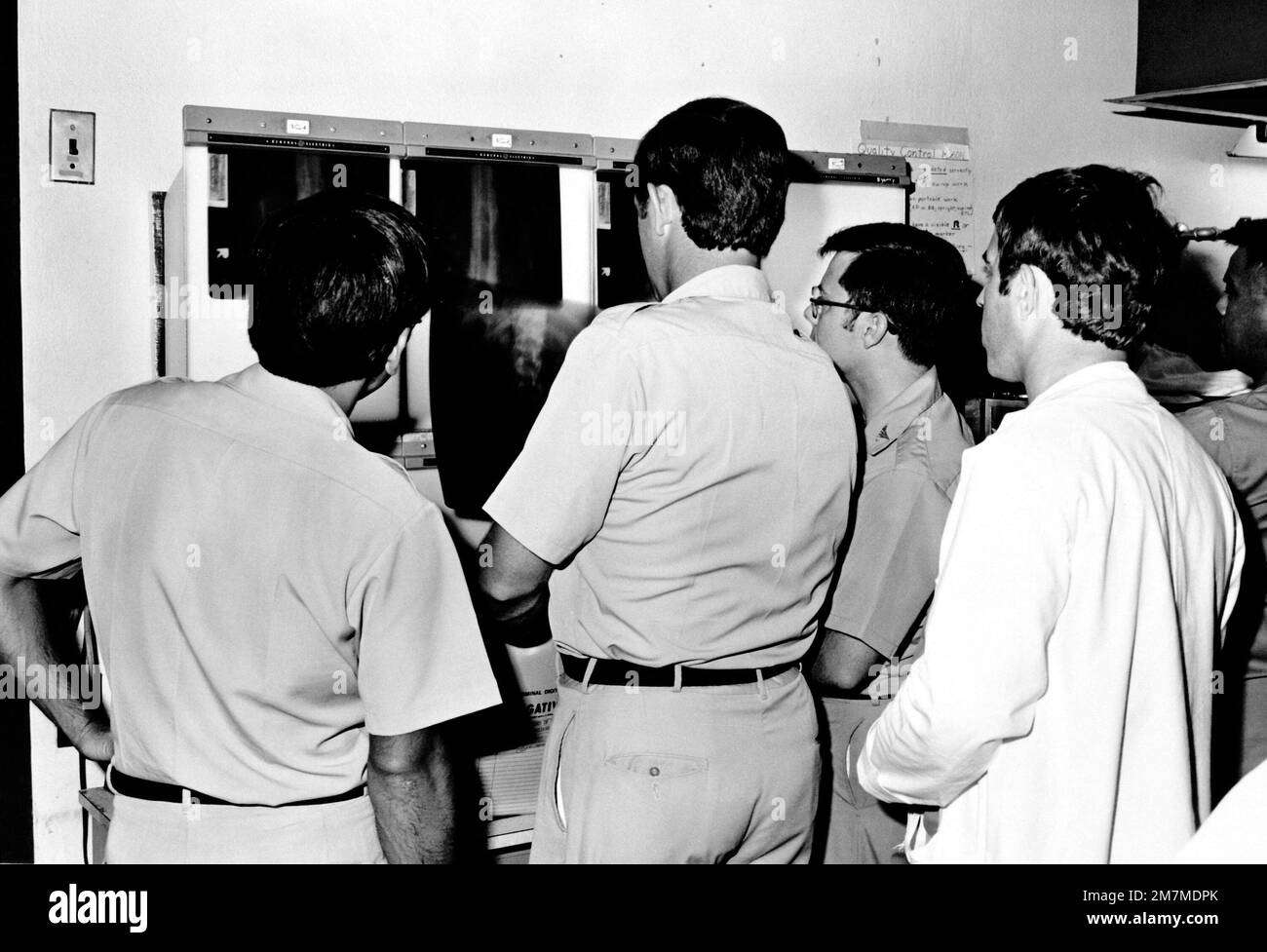 Un team di medici utilizza una casella di visualizzazione per esaminare i raggi X di un paziente nella Radiology Clinic degli Stati Uniti Army Hospital, Camp Kuwae. Base: Camp Kuwae Stato: Okinawa Nazione: Giappone (JPN) Foto Stock