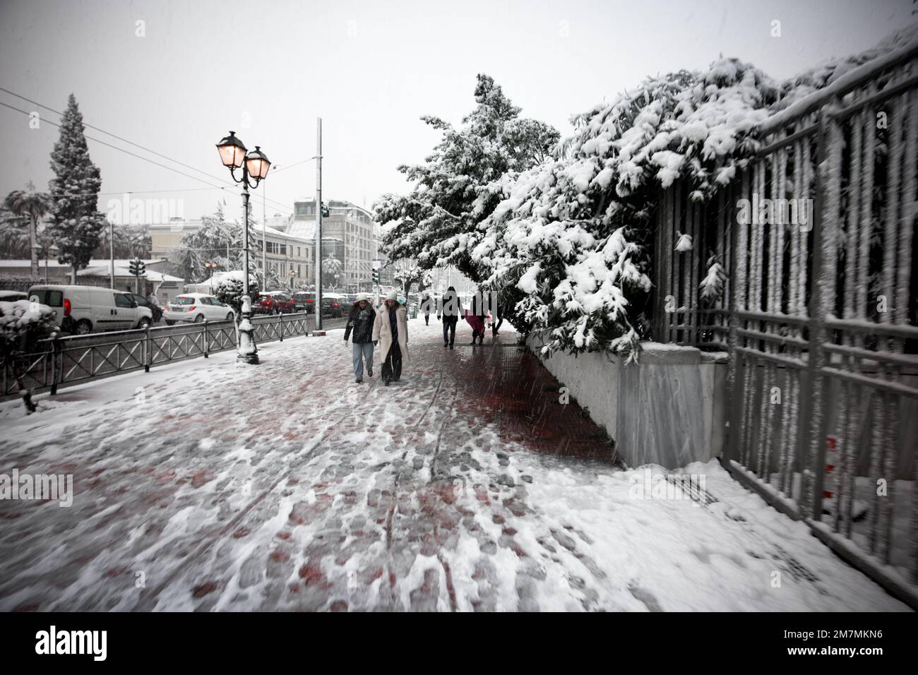 Un'immagine colorata selettiva di persone che camminano su un marciapiede coperto di neve durante l'inverno Foto Stock
