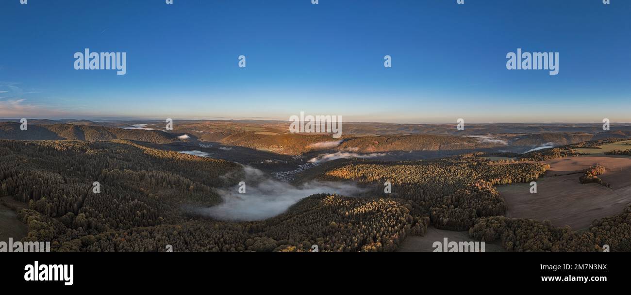 Germania, Turingia, Schwarzburg, Schwarzatal panoramica, piccola città, castello, valle, montagne, foresta, nubi di nebbia, luce mattutina, foto panoramica Foto Stock