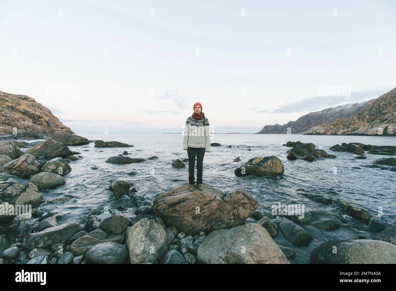 Giovane donna con cappuccio rosso sulla spiaggia Foto Stock
