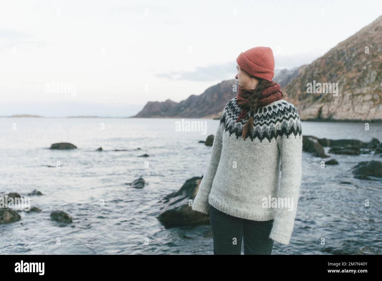 Giovane donna con cappuccio rosso sulla spiaggia Foto Stock