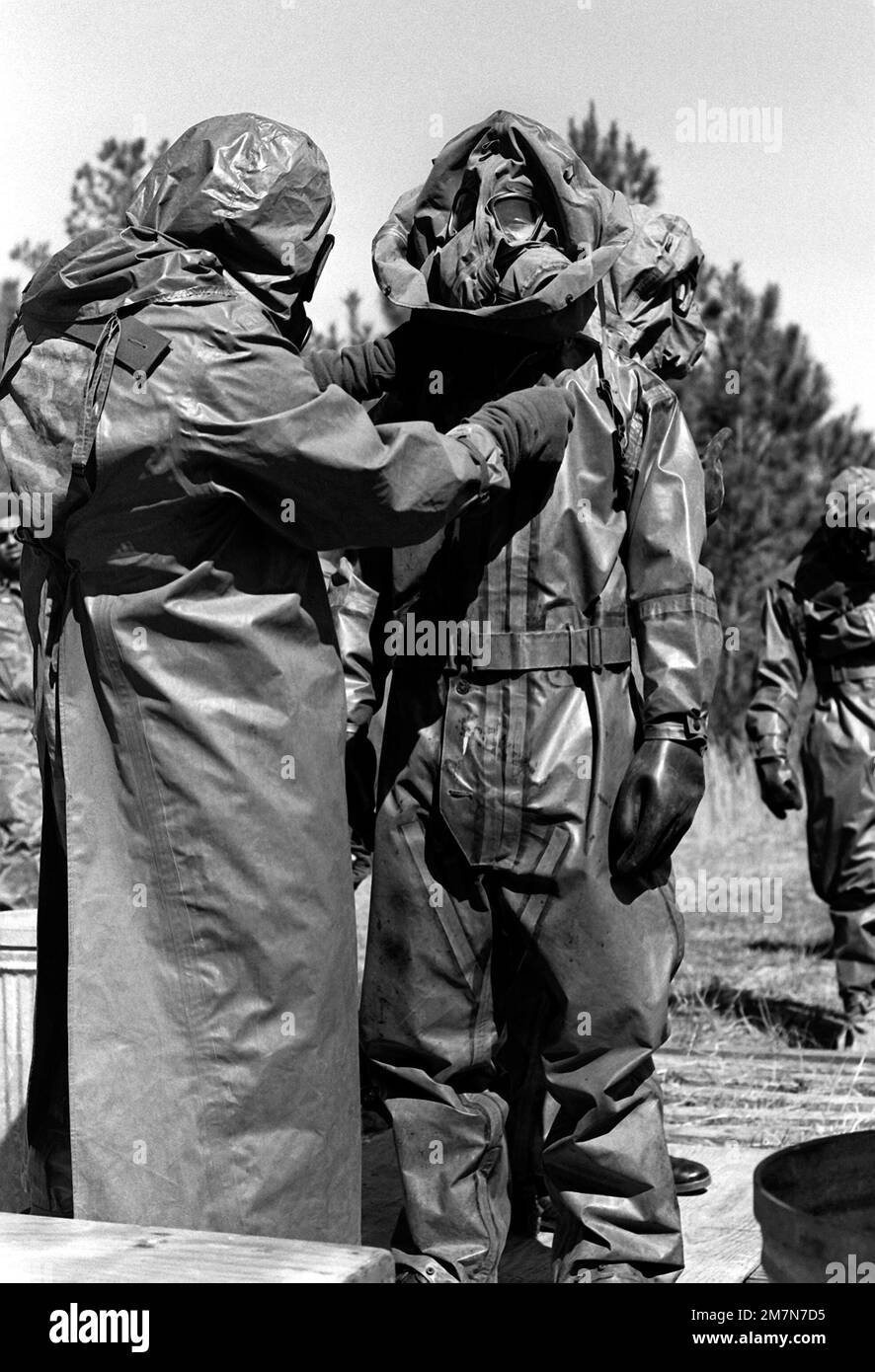 Ogni Marina aiuta l'altro a vestirsi di abbigliamento da guerra per la difesa nucleare, biologica e chimica presso la scuola. Base: MCA, Cherry Point Stato: North Carolina (NC) Paese: Stati Uniti d'America (USA) Foto Stock